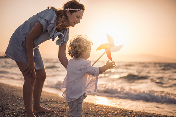 Mutter spielt mit Kind am Strand